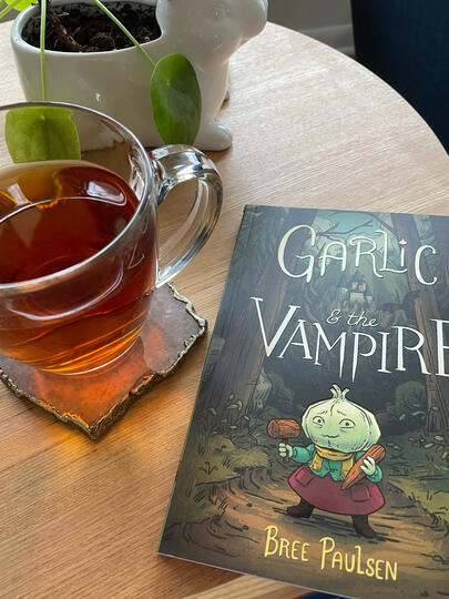 Garlic and the Vampire Garlic and the Vampire book by Bree Paulsen sitting on a side table next to a mug of tea.