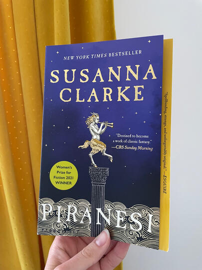 Piranesi Hand holding up Piranesi book by Susanna Clarke.